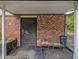 Covered exterior space with brick, features seating and a security door, adding charm and functionality at 2497 Mobley Se Ct, Atlanta, GA 30315