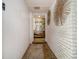 Hallway with white brick accent wall and carpeted floors, leading to a bright interior with staircase at 2497 Mobley Se Ct, Atlanta, GA 30315