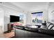 Bright living room with city views, featuring hardwood floors, a large sectional sofa, and a modern entertainment center at 3445 Stratford Ne Rd # 3601, Atlanta, GA 30326