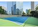 Well-maintained tennis court surrounded by lush landscaping, benches, and tall buildings at 3445 Stratford Ne Rd # 3601, Atlanta, GA 30326