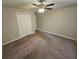 Neutral bedroom features carpet, a ceiling fan, and double-door closet at 215 Moseley Crossing Dr, Stockbridge, GA 30281