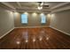 Spacious bedroom featuring hardwood floors, tray ceiling, recessed lighting, and two windows at 215 Moseley Crossing Dr, Stockbridge, GA 30281