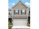 Tan two-story townhome with white garage door and dark brown shutters at 21 Crescent Chase Dr, Dallas, GA 30157