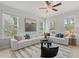 Bright living room featuring a large sectional sofa, ceiling fan, and natural light from the surrounding windows at 3136 Washburn Se St, Atlanta, GA 30354