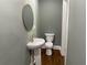Updated bathroom with pedestal sink and dark wood floors at 1677 S Gordon Sw St, Atlanta, GA 30310