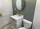 Modern bathroom with white vanity, updated toilet, and a round mirror at 1677 S Gordon Sw St, Atlanta, GA 30310