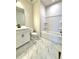 Bathroom featuring marbled floors, white cabinetry, a vanity sink, toilet, and shower with built-in shelves at 738 Crossroad Ct, Powder Springs, GA 30127