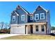 Two-story home with navy siding, a white garage door, a covered porch, and white brick accents at 738 Crossroad Ct, Powder Springs, GA 30127