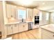 The kitchen with white cabinets, quartz countertops, stainless steel appliances, and light wood flooring at 738 Crossroad Ct, Powder Springs, GA 30127