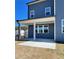 Outdoor patio area with blue siding, white pillars, multiple windows, and manicured lawn at 738 Crossroad Ct, Powder Springs, GA 30127