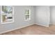 Neutral-toned bedroom with natural light from two windows and light wood laminate flooring at 404 Beacon Way, Villa Rica, GA 30180