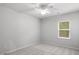 Simple bedroom featuring neutral carpet, a ceiling fan, and a single window for natural light at 404 Beacon Way, Villa Rica, GA 30180