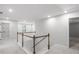Second floor hallway landing featuring gray carpet, wooden railing, and doors to other rooms at 404 Beacon Way, Villa Rica, GA 30180