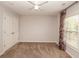 Neutral bedroom featuring a ceiling fan, carpet, and a window with floral-patterned curtains at 2382 Gallard St, Lawrenceville, GA 30043