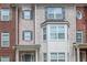 Brick townhome featuring windows with shutters and an arched entryway and covered porch at 2382 Gallard St, Lawrenceville, GA 30043