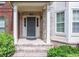 Charming brick home entry featuring a gray front door, white columns, and lovely landscaping at 2382 Gallard St, Lawrenceville, GA 30043