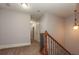 Second floor hallway with carpet, a light fixture, and stained wooden railing and banister at 2382 Gallard St, Lawrenceville, GA 30043