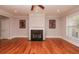 Living room featuring a fireplace with a black granite hearth, hardwood floors, and natural light at 2382 Gallard St, Lawrenceville, GA 30043