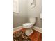 Cozy toilet with hardwood floors, baseboard trim, and a unique dog art piece at 2382 Gallard St, Lawrenceville, GA 30043