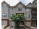 Exterior shot of a townhome highlighting gray siding, brick accents, and attached garages at 2382 Gallard St, Lawrenceville, GA 30043