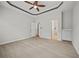 Open bedroom with tray ceiling, neutral walls, and doorway leading to an en-suite bathroom at 6329 Edgewater Cv, Fairburn, GA 30213
