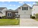 Charming two-story home with a stone accent wall, lush green lawn, and a two-car attached garage at 6329 Edgewater Cv, Fairburn, GA 30213