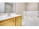 Bathroom featuring a wood vanity, sink, mirror, and tub with tile surround at 6693 Villa Ct # 6693, Lithonia, GA 30038