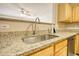 Kitchen features stainless steel sink, wooden cabinets and view to living room at 6693 Villa Ct # 6693, Lithonia, GA 30038