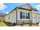 View of the exterior with a mix of vinyl siding and brick with black shutters and a manicured yard at 134 Oakchase Park Ln, Hampton, GA 30228