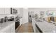 Open kitchen featuring granite countertops, stainless steel appliances, and wood flooring at 134 Oakchase Park Ln, Hampton, GA 30228