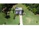 Aerial view of a well-maintained home with a large yard, landscaping, and a long driveway surrounded by lush greenery at 7030 Valley Landing Ct, Cumming, GA 30041
