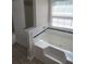 Bathroom featuring a relaxing soaking tub with tile surround and a window for natural light at 7030 Valley Landing Ct, Cumming, GA 30041