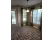 Bright dining area featuring tiled floors, neutral walls, and multiple windows dressed with modern curtains at 7030 Valley Landing Ct, Cumming, GA 30041