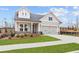 Charming two-story home with a gray exterior, well-manicured lawn, and a two-car garage at 214 Strawberry Ln, Woodstock, GA 30189