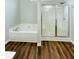 Bathroom featuring tub and stand-alone shower, complimented by wood-look floors at 306 Mountain Laurel Walk, Canton, GA 30114