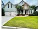 Inviting two-story home boasts a well-kept lawn, two-car garage, and covered front porch at 306 Mountain Laurel Walk, Canton, GA 30114