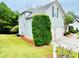 Side view of a two-story house with a large green bush at 306 Mountain Laurel Walk, Canton, GA 30114