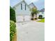 Exterior view of the home featuring an attached two-car garage and concrete driveway at 306 Mountain Laurel Walk, Canton, GA 30114