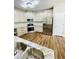 Open concept kitchen with stainless refrigerator, tile backsplash and wood-look flooring at 306 Mountain Laurel Walk, Canton, GA 30114