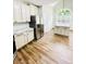 Bright kitchen featuring white cabinets, stainless steel appliances, and beautiful hardwood floors at 306 Mountain Laurel Walk, Canton, GA 30114
