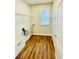 Functional laundry room with basin, wire shelving, window and wood-look flooring at 306 Mountain Laurel Walk, Canton, GA 30114