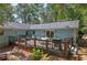 View of the home's back deck with grill, table and chairs, and outdoor seating surrounded by trees at 294 Puckett Se Rd, Emerson, GA 30137