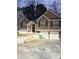 Two-story house with brown siding, two-car garage, and a landscaped yard at 6922 Magnolia Park Dr, Norcross, GA 30093