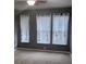 Neutral bedroom featuring three windows dressed with white sheer curtains and blinds at 898 Oak Sw St # 3108, Atlanta, GA 30310