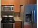 Stainless steel kitchen appliances including a refrigerator, range, and microwave blend with the cabinets at 898 Oak Sw St # 3108, Atlanta, GA 30310