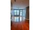 Hardwood floors lead to a bright living space with a ceiling fan, a large window, and a glass door to a balcony at 898 Oak Sw St # 3108, Atlanta, GA 30310