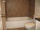 Bathroom with brown tile, bathtub, and toilet at 3982 Woodridge Way, Tucker, GA 30084