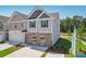 Two-story townhome with gray and beige exterior, white garage door, and landscaping; aerial view at 158 Switcher Ct, Union City, GA 30291