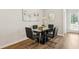 Modern dining room with glass table, black chairs, and hardwood floors at 158 Switcher Ct, Union City, GA 30291