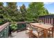 Wooden deck with table, chairs, and lush green trees in the background at 5317 Concordia Pl, Mableton, GA 30126